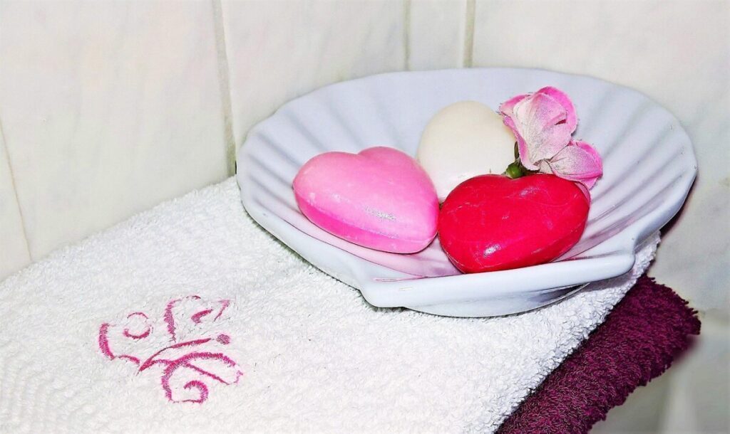 Colored bars of soap in a shell-shaped dish on a towel
