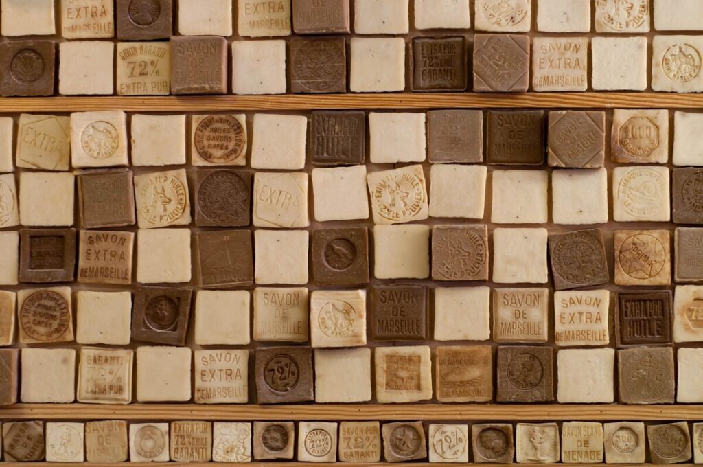 Wall of Marseille soap cubes in many colors on wooden shelves