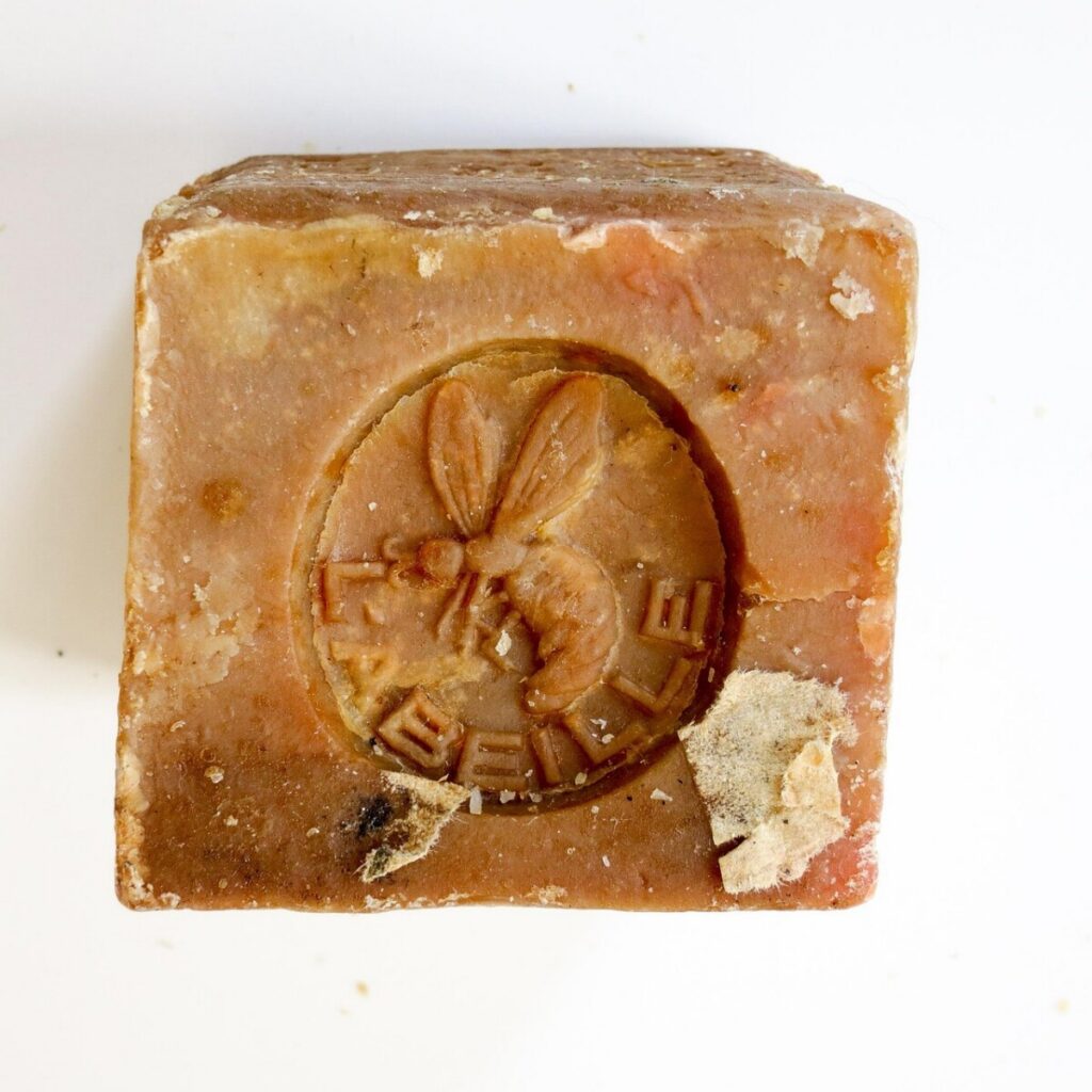 Worn block of Marseille soap with bee stamp