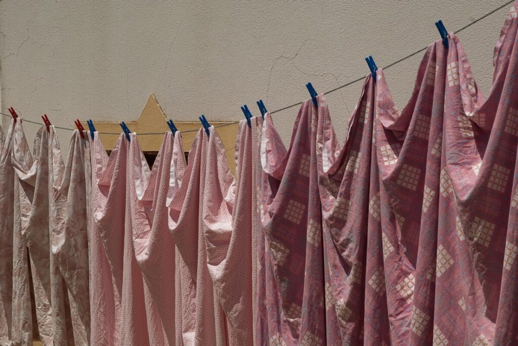 White laundry and socks drying on a clothes rack